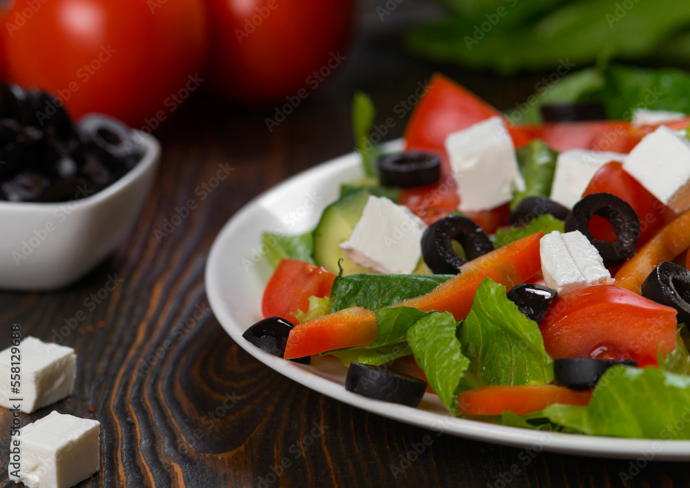 Greek salad. Vegetable salad with tomato, cucumber, salad leaves, feta cheese and olive oil.