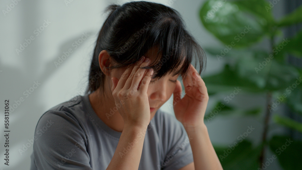 Asian woman was sick with headache sitting at home office. Close-up shot. Asian woman was sick with headache sitting at home office. Close-up shot.
