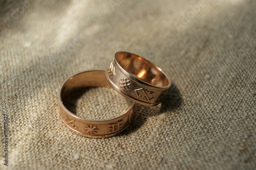 Wedding rings with symbols on natural linen fabric.