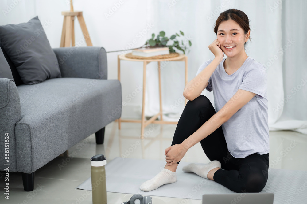 Young asian woman attractive exercises workout at home and watching Online sports tutorials over laptop Young asian woman attractive exercises workout at home and watching Online sports tutorials over laptop