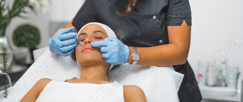 Medium shot of a woman receiving a collagen injection. Lip filer. Aesthetic medicine concept. Beauty concept. High quality photo