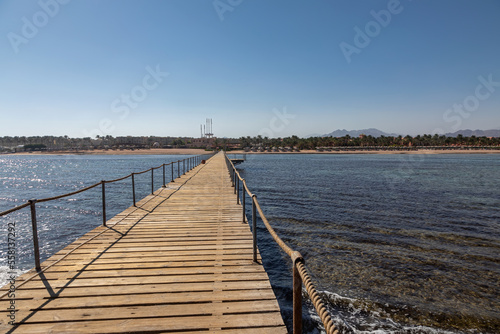 Wallpaper Mural Beautiful beach with a long pier. Yellow sand. Sunny summer day. Blue sky. Transparent beautiful sea. Torontodigital.ca