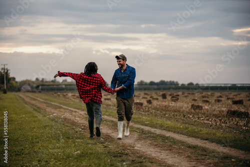 Happy multiethnic couple holding hands while walking, running, dancing, and talking in nature.