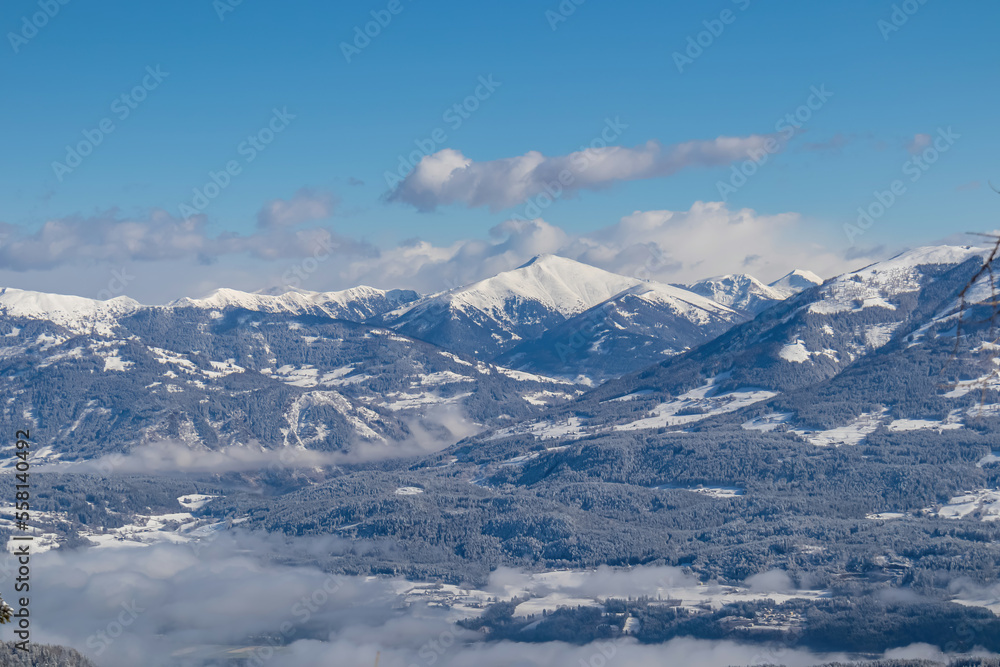 Panoramic view of the snowcapped mountain ranges of the Nock Mountains (Nockberge) seen from Kobesnock near Bad Bleiberg, Carinthia, Austria, Europe. Rosennock in winter wonderland alpine landscape