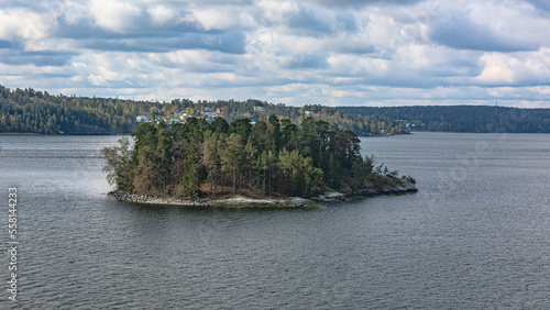 Landscape with Scandinavian skerries in the Gulf of Bothnia of the Baltic Sea. A unique natural landscape with rocky islets, overgrown with forest, with neat houses and piers