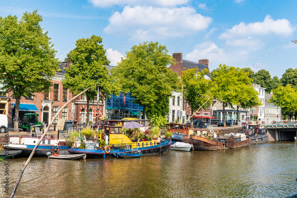 Groningen, Netherlands-August 16, 2022: cityscape with old and colorful boats moored along the canal in the historic city center