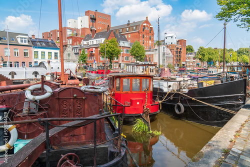 Groningen, Netherlands-August 16, 2022: cityscape with old and colorful boats moored along the canal in the historic city center