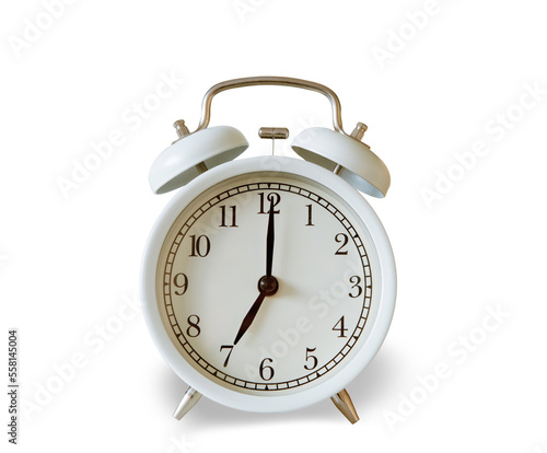 White vintage alarm clock showing 7.00 o'clock isolated on white background.