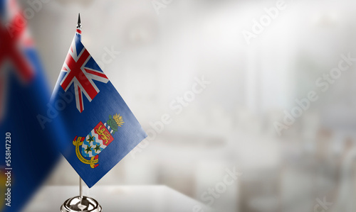 Small flags of the Cayman Islands on an abstract blurry background photo