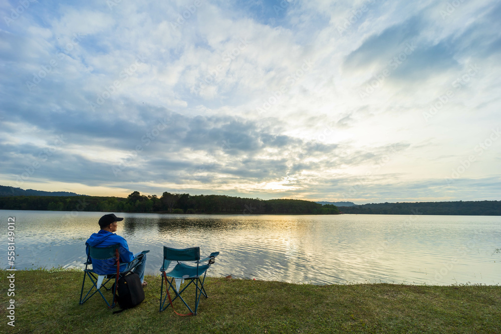 The man sitting on the riverside watching the sunset. The man sitting on the riverside watching the sunset.