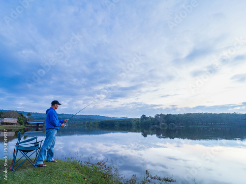 Man enjoys catching fish in the background natural blue sky.