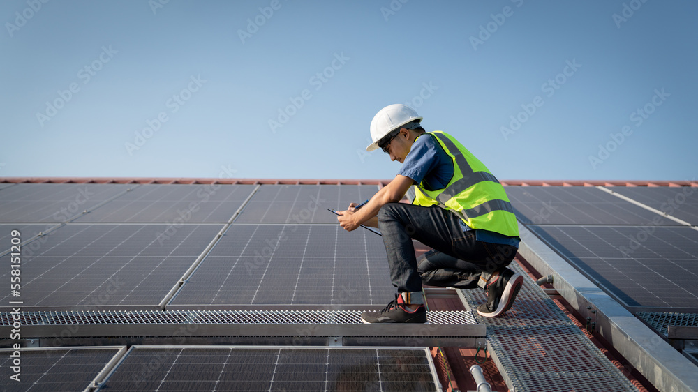 Service engineer checking solar cell on the roof for maintenance if there is a damaged part., Clean energy concept. Service engineer checking solar cell on the roof for maintenance if there is a damaged part., Clean energy concept.