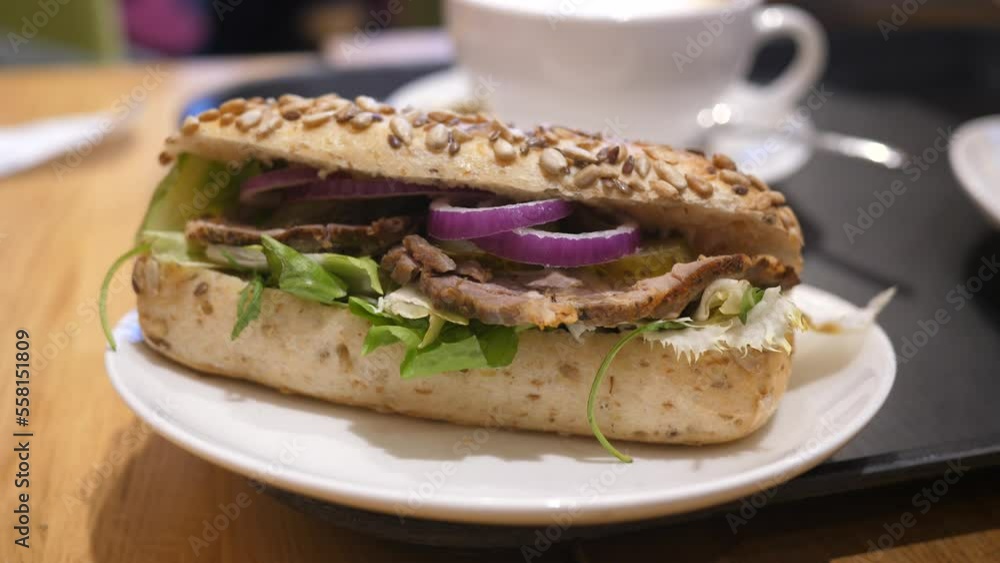 Bakery gastro bar person eating tasty sandwich with pork meat and vegetables Bakery gastro bar person eating tasty sandwich with pork meat and vegetables