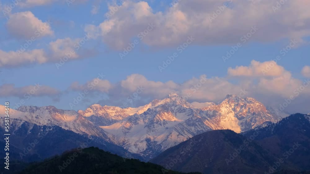 Rocky mountain peaks illuminated by soft sunset light Rocky mountain peaks illuminated by soft sunset light