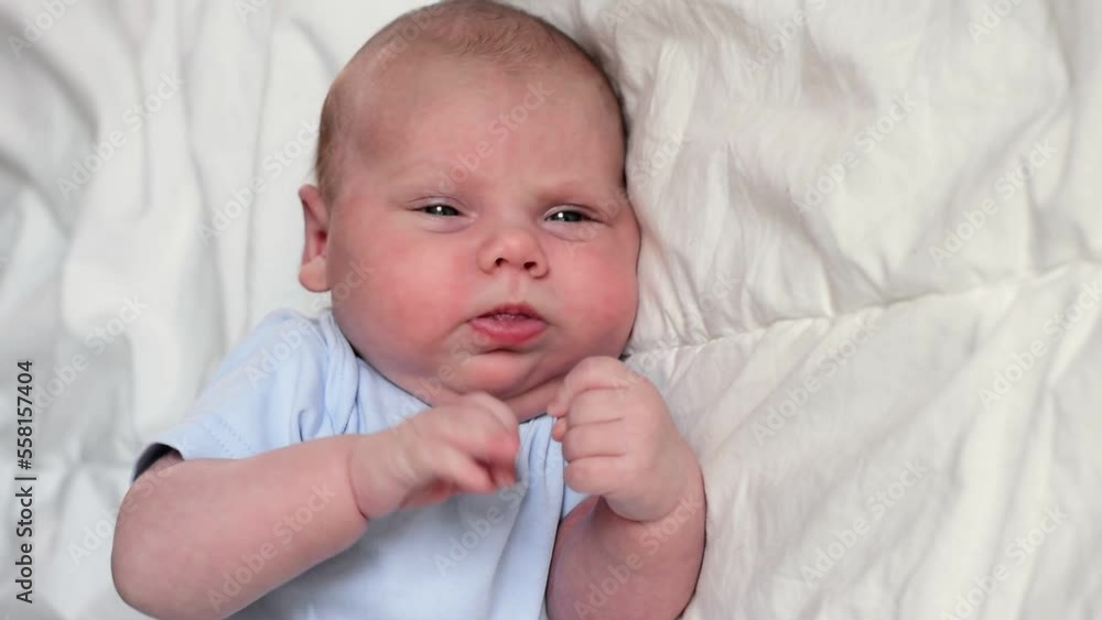 Closeup portrait of Newborn baby on white blanket. Soft focus. Infant