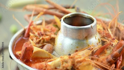 Tom Yam Kung or Tom Yum soup is Thai hot spicy soup shrimp or prawn with lemon grass, lemon, galangal, mushrooms, coconut milk and chili in bowl  Thai food cuisine.