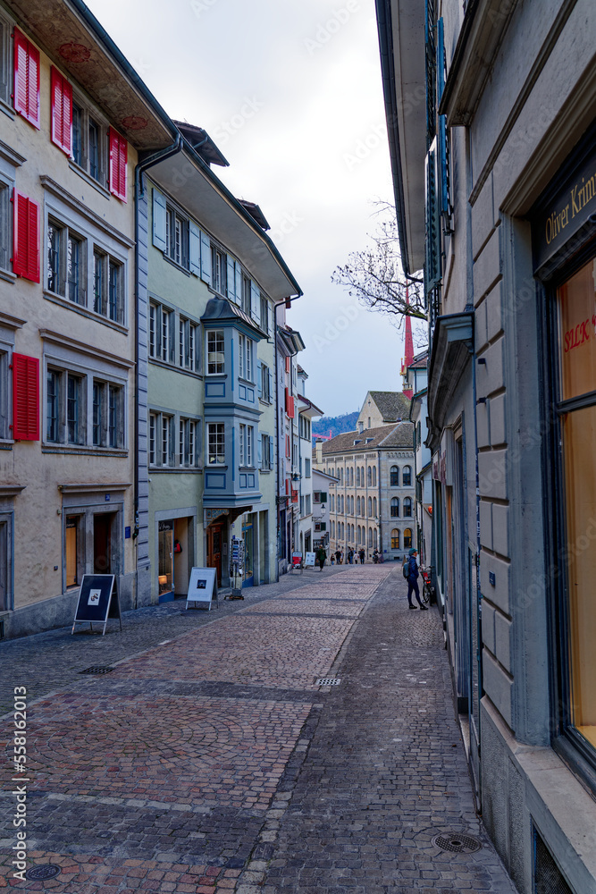 Church alley at the medieval old town of Zürich with historic houses on a cloudy autumn late afternoon. Photo taken November 4th, 2022, Zurich, Switzerland.