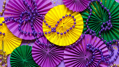 Mardi gras.Holidays mardi gras masquarade  venetian mask  fan over purple background. view  above mardi gras background copy space Happy Mardi Gras . Fat Tuesday carnival texture golden green purple