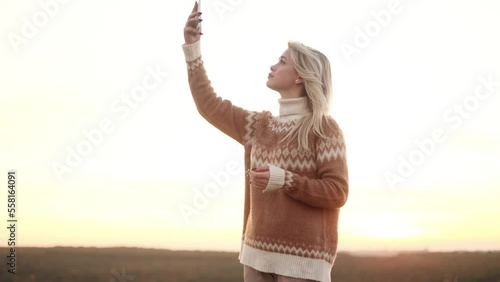 Attractive young woman trying to pick up the signal on her mobile phone in the mountains Charming girl trying to use smartphone but no signal outdoors alone photo