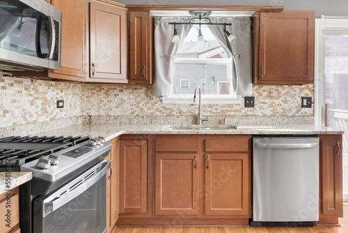 Builder Grade Kitchen with Oak Shaker Cabinets and Stainless Steel Appliances. Basic Kitchen in rental apartment.