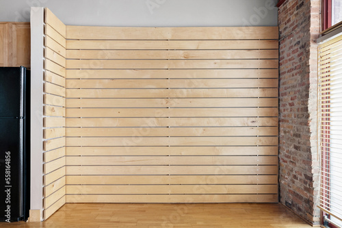 Empty Oak Slat Accent Wall. Vacant living room for virtual staging. Wood and brick accents in industrial style loft.