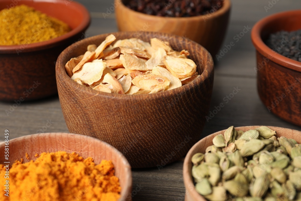 Many different spices on grey wooden table, closeup