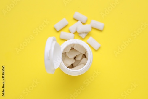 Jar with chewing gums on yellow background, flat lay