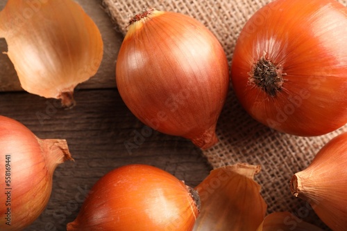 Many ripe onions on wooden table  flat lay
