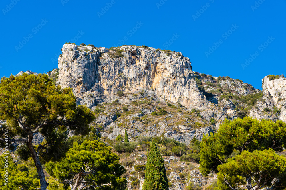 Panoramic view of Alpes mountains and rocky cliffs over Eze sur Mer resort town on French Riviera Coast of Mediterranean Sea in France