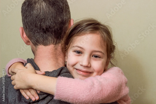a smiling girl hugs her father