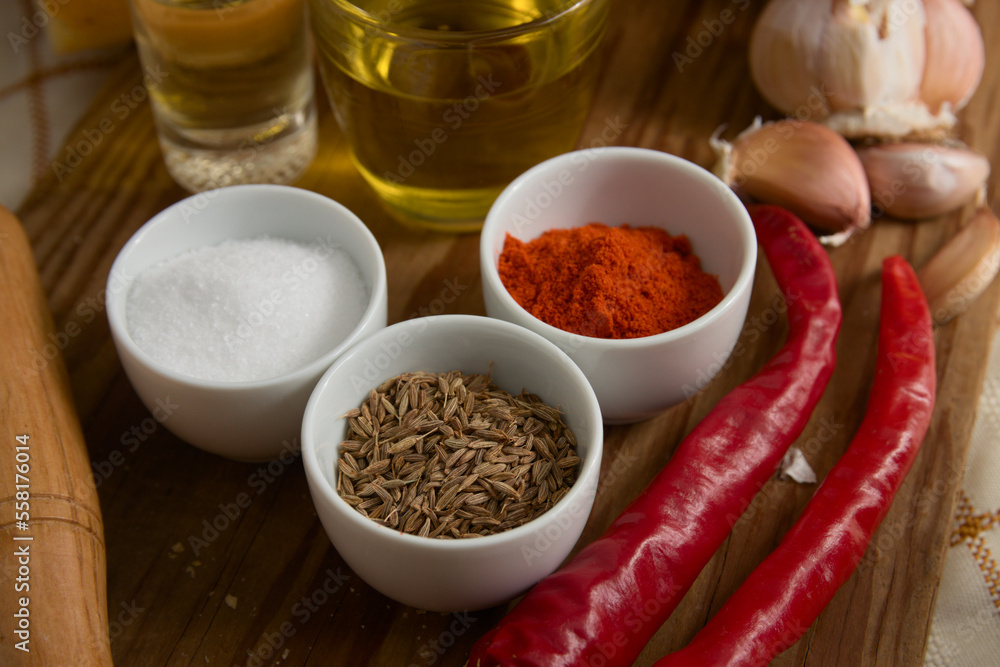 Close-up of different spices, such as paprika powder, garlic heads, salt, red pepper, oil Close-up of different spices, such as paprika powder, garlic heads, salt, red pepper, oil