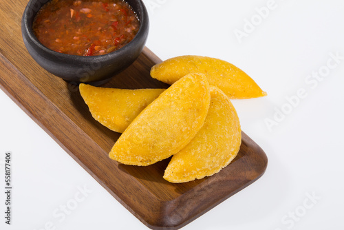 Colombian empanada with spicy sauce - on the white background.traditional colombian food