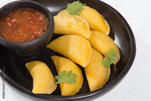 Colombian empanada with spicy sauce - on the white background.traditional colombian food
