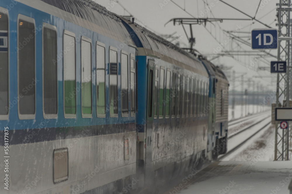 Passenger train near stop in Veseli nad Luznici with snowy platforms