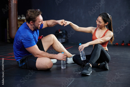 trainers or athletics greeting with fist after workout in the gym
