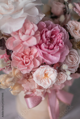 A luxurious bouquet of flowers in a hat box. Composition with pink and white flowers and eucalyptus in a round box. Modern Floristry.