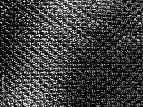 the background is a contrasting black structural mesh fabric with holes