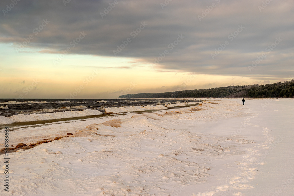 winter landscape from the seashore, lying pieces of ice on the seashore, sand and ice texture in the dunes