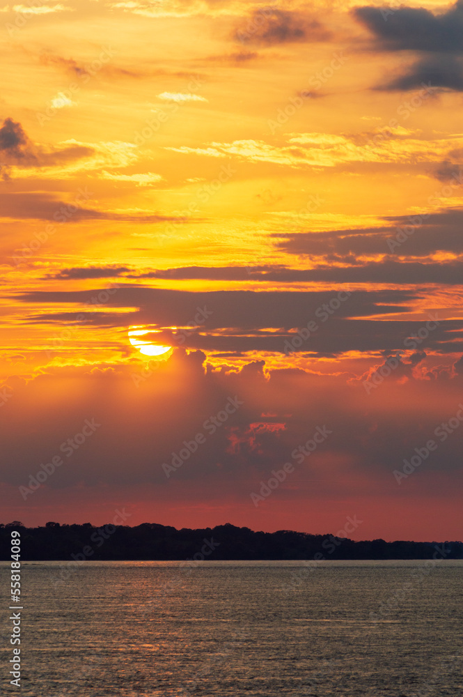 Amazing sunrise on the water of Amazon river in Brazil, nice soft warm light seeping through the clouds