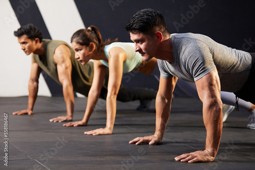 young athletic man doing push up with on the gym floor