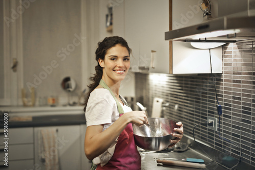young woman prepares dinner in the kitchen