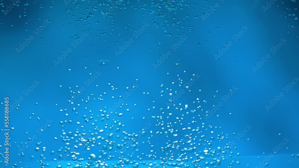 Underwater view of stream of air bubbles rising onto the surface of blue water from the depth. Close up of oxygen bubbles appearing on the surface of the liquid and bursting. Slow motion. Underwater view of stream of air bubbles rising onto the surface of blue water from the depth. Close up of oxygen bubbles appearing on the surface of the liquid and bursting. Slow motion.
