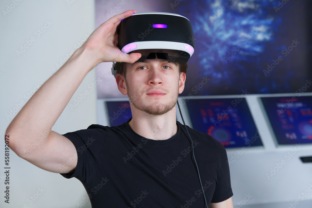 Portrait of happy young handsome man, guy using, wearing a modern device virtual reality headset mask or 3D, AR, VR glasses, playing the game. People and technology metaverse concept Portrait of happy young handsome man, guy using, wearing a modern device virtual reality headset mask or 3D, AR, VR glasses, playing the game. People and technology metaverse concept