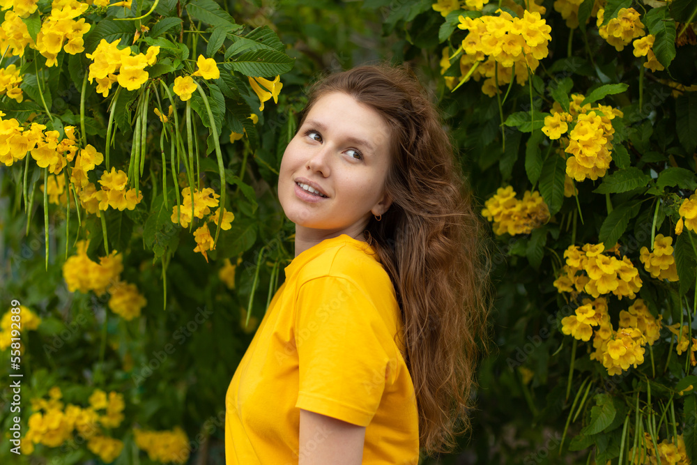 Portrait of happy beautiful bearded girl, young positive woman with beard is smelling beautiful yellow flowers in the garden, smiling, enjoying spring or summer day, breathing deep deeply fresh air Portrait of happy beautiful bearded girl, young positive woman with beard is smelling beautiful yellow flowers in the garden, smiling, enjoying spring or summer day, breathing deep deeply fresh air