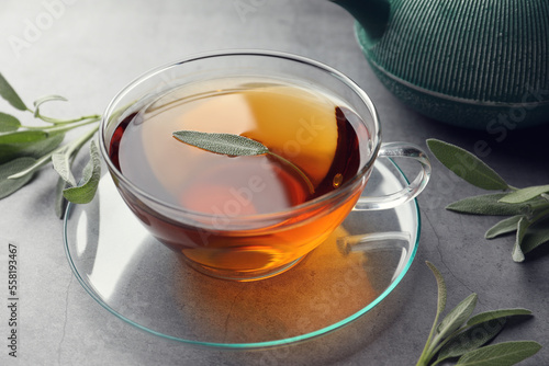 Fototapeta Naklejka Na Ścianę i Meble -  Cup of aromatic herbal tea with sage on grey table