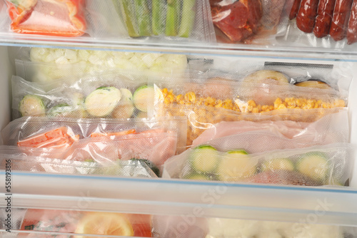 Vacuum bags with different products in fridge, closeup. Food storage