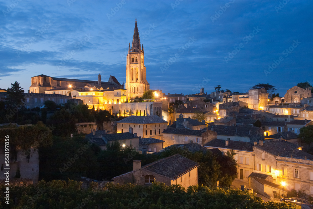 Overview of illuminated Saint Emilion village at dusk, famous for vineyards, in Bordeaux region, France