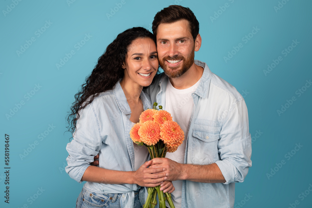 Happy young international couple hold bouquet of flowers, celebrate holiday, enjoy date and romantic Happy young international couple hold bouquet of flowers, celebrate holiday, enjoy date and romantic