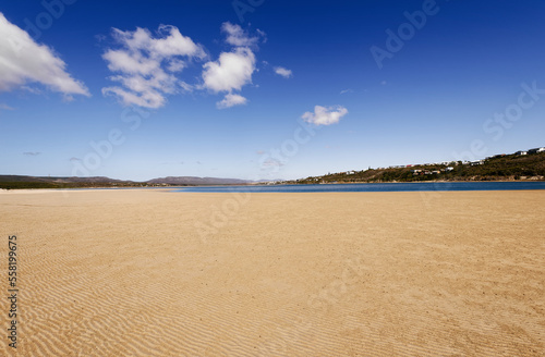 A beautiful view over the coastline of Witsand, South Africa, with blue skies and sunny weather. Millions of little sand balls made by crabs are visible on the beach. photo