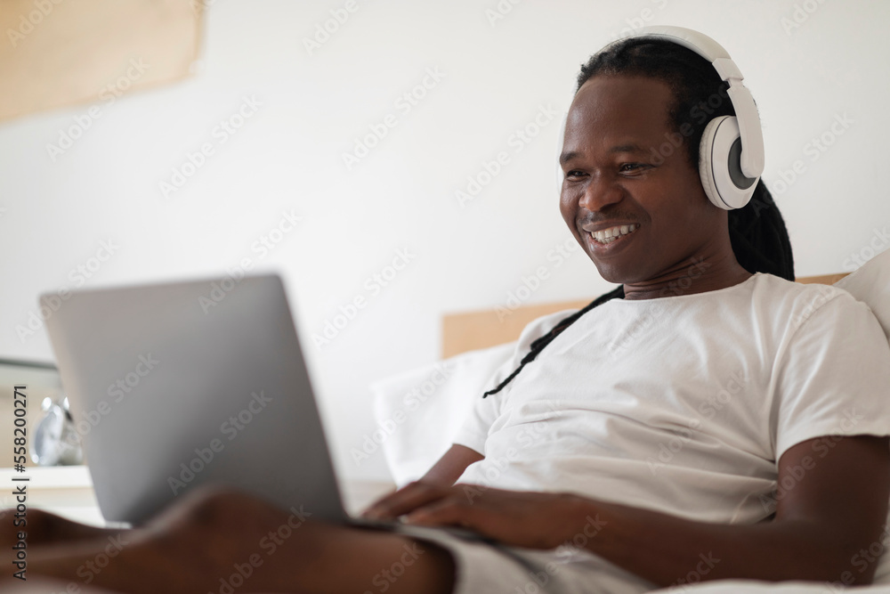 Online Education. Young Black Man Study With Laptop While Sitting In Bed Online Education. Young Black Man Study With Laptop While Sitting In Bed